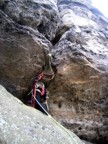 Making the crux moves at the start of the route -- an overhanging offwidth crack protected by jammed knots, the first knots I placed in Elbsandstein